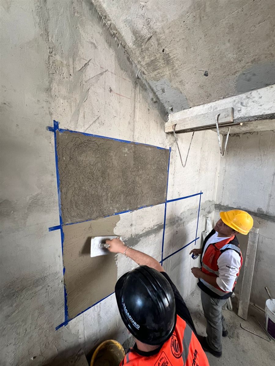 Aplicación de adhesivo Pegaduro sobre muro de concreto durante una demostración en obra